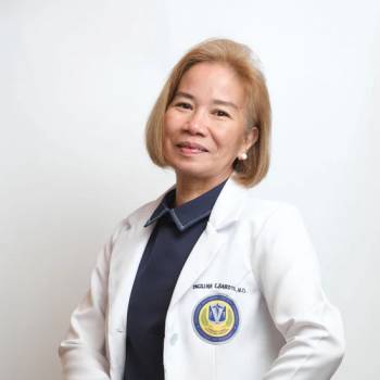 Douglas S Harrington MD vilkintis juodą smokingą ir varlytę, stovi priešais banerį su logotipais, įskaitant Oscars ir HeartDaHeart Foundation, oficiali renginio aplinka, neutralus ir profesionalus įspūdis, matomas tekstas: Oscars HeartDaHeart Foundation UnmaskHeartDisease